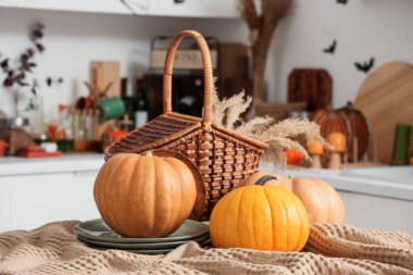 Mutfaktaki masada tabak ve sepetli Cadılar Bayramı balkabakları, yakın plan.