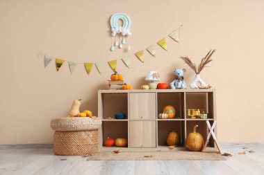 Rafların, balkabaklarının ve oyuncakların olduğu çocuk odasının içinde.