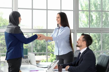 İnsan Kaynakları Yöneticisi görevde Müslüman adayla tokalaşıyor