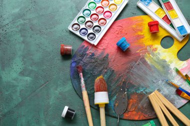 Fırçalı palet ve grunge yeşil arka planda boyalar