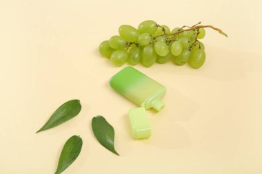 Sarı arka planda üzümlü elektronik sigara.