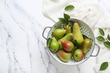 Beyaz mermer masa üzerinde olgun armutlar ile Colander