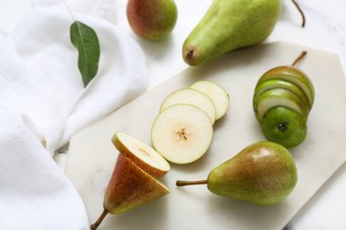 Beyaz mermer masa üzerinde olgun armutlar olan tahta, yakın plan.