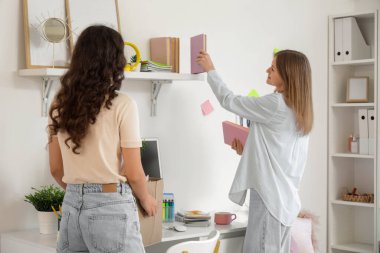 Yurt odasındaki eşyaları boşaltan kız öğrenciler taşınma günü, arka plan