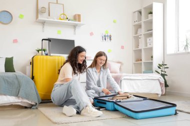 Yurt odasındaki bavulları boşaltan kız öğrenciler