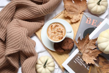 Bir fincan lezzetli balkabağı kahvesi, kurabiyeler, dergiler ve sıcak süveter.