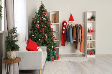 Koridorun içinde Noel ağacı, kanepe ve askılık var.