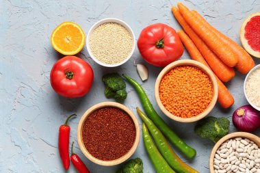 Mavi arka planda farklı taze sebzeler ve tahıllar.