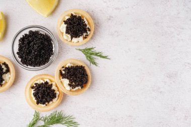 Hafif arka planda siyah havyarlı lezzetli tartlar.