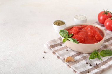 Hafif arka planda konserve domates ve baharatla dolu bir kase.