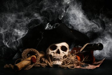 Oyuncak top modelli insan kafatası, korsan şapkası, dünya haritası ve siyah arka planda parşömen.