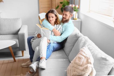 Aşık mutlu çift evde kitap okuyor.