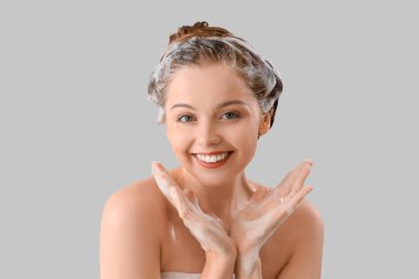 Young woman with shampoo on light background, closeup clipart