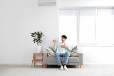 Genç adam çalışma odasındaki kanepede dinleniyor.