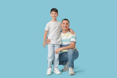 Mavi arka planda babası olan sevimli küçük bir çocuk.