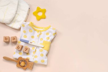 Elbiseli kompozisyon, bebek bezi, hamilelik testi ve pembe arka planda bebek kelimesi.