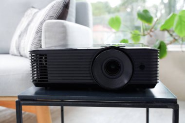 Oturma odasındaki masada video projektörü, yakın plan.