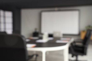 Masa ve projektör ekranlı konferans salonunun bulanık görüntüsü