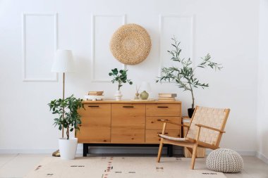 Ahşap klozeti, koltuğu ve bitkileri olan ışık odasının içi.