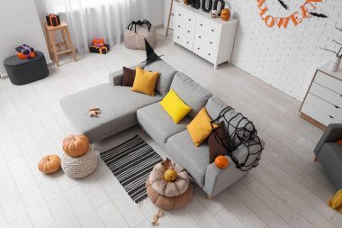 Oturma odasının içinde kanepe, hediyeler ve Cadılar Bayramı balkabaklarıyla