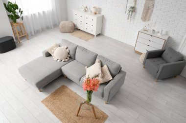 Oturma odasının içinde, masasında vazo ve gladiolus çiçekleri olan bir masa.