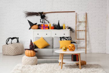 Cadılar Bayramı için dekore edilmiş oturma odasının içi kanepe, masa ve balkabaklarıyla dolu.