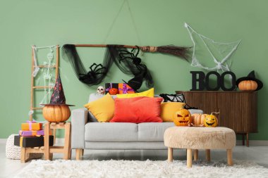 Cadılar Bayramı için kanepe, balkabağı ve hediyelerle dekore edilmiş oturma odasının içi.