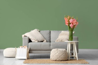 Masasında vazo ve gladyatör çiçekleri olan şık bir oturma odası.