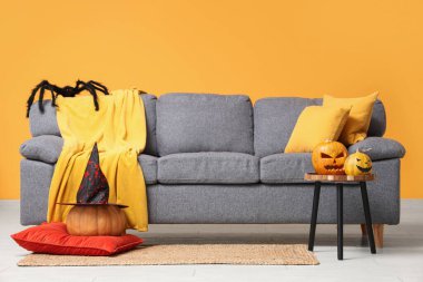 Oturma odasının içinde kanepe, masa ve Cadılar Bayramı balkabakları var.