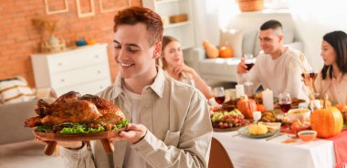 Şükran Günü 'nde hindi yiyen genç adam.