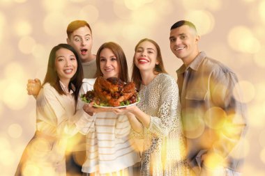 Bej arka planda lezzetli hindi olan bir grup genç arkadaş. Şükran Günü kutlaması