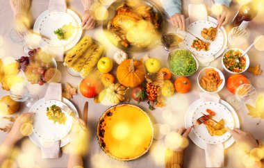 Şükran Günü için yemek masasında lezzetli yemekleri olan bir aile.