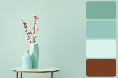 Odadaki nane duvarının yanındaki masada pamuk çiçekli vazolar. Farklı renk desenleri