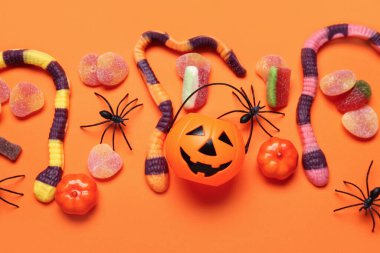 Tatlı jöle şekerli kompozisyon ve renkli arka planda Cadılar Bayramı süslemeleri