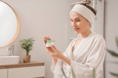 Banyoda bir kavanoz kremalı güzel bir kadın.