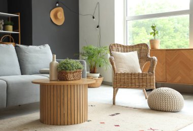 Koltuk, hasır koltuk ve oturma odasının içindeki ahşap masa.