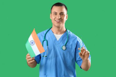 Hindistan bayrağı ve yeşil arka planda şırıngası olan bir erkek doktor. Ulusal Doktorların Günü kutlaması