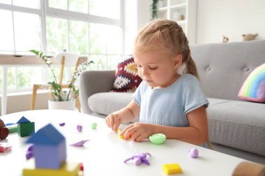 Evde plastikten heykel yapan sevimli küçük kız.