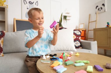 Evdeki plastikten heykel yapan tatlı küçük çocuk.