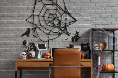 İş yeri ve raf ünitesi ile Cadılar Bayramı için dekore edilmiş ofis.