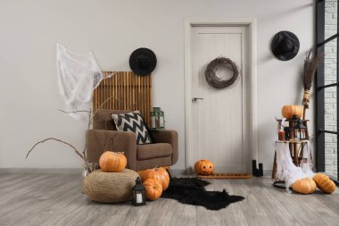 Koridorun içi Cadılar Bayramı için kapı, koltuk ve balkabaklarıyla süslenmiş.