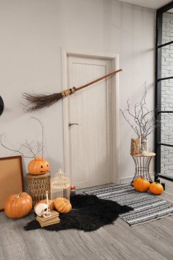 Koridorun içi Cadılar Bayramı için kapı, cadı süpürgesi ve balkabağıyla süslenmiş.