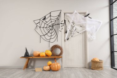 Koridorun içi Cadılar Bayramı için kapı, bank ve balkabaklarıyla süslenmiş.