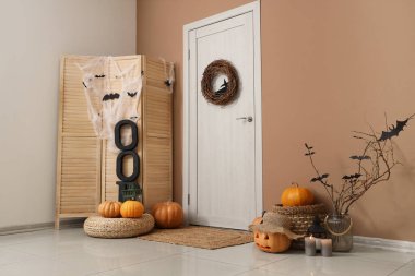 Cadılar Bayramı için dekore edilen koridorun içi kapı, katlama perdesi ve balkabaklarıyla süslenmiş.