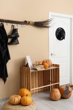 Koridorun içi Cadılar Bayramı için kapı, cadı kostümü ve balkabaklarıyla süslenmiş.