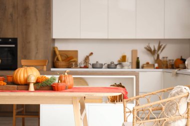 Mutfaktaki yemek masasında sonbahar dekoru olan balkabakları.