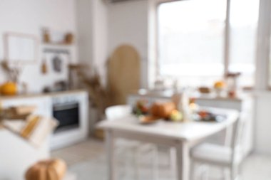 Güz dekorlu, tezgahlı ve yemek masalı aydınlık mutfağın bulanık görüntüsü