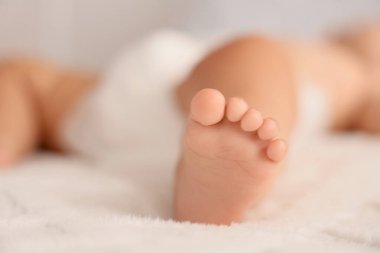 Küçük şirin bebek ayağı yatakta, yakın plan.