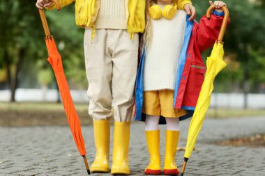 Sonbahar günü şemsiyeli çocuklar parkta