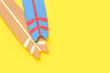 Sarı arka planda küçük renkli sörf tahtaları